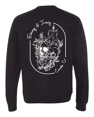back of a Black, ebony and ivory candle co crew neck sweater with a white design of a skull with a melting candle stick on it's head, surrounded by flowers