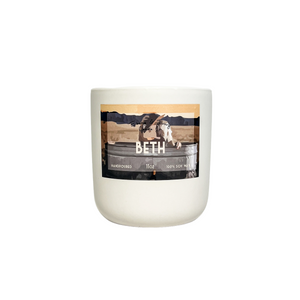 White, eleven ounce, cherry, cedar wood, and amber scented soy wax candle labeled Beth