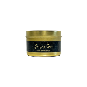 Gold four ounce, lavender, cedar, and cardamom scented soy wax candle with a gold lid and a black label that reads Amazing Grace