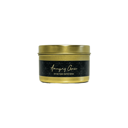 A gold 4oz tin soy candle on a white background with a black label that's named Amazing Grace, made by Ebony & Ivory Candle Co in Lethbridge, Alberta, Canada