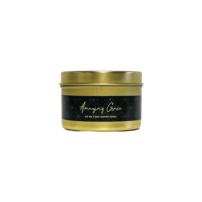 A gold 4oz tin soy candle with a gold lid and a black label named Amazing Grace on a white background, made by Ebony & Ivory Candle Co in Lethbridge, Alberta, Canada