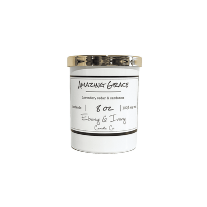 A white 8oz jar soy candle with a gold lid and a white label named Amazing Grace on a white background, made by Ebony & Ivory Candle Co in Lethbridge, Alberta, Canada