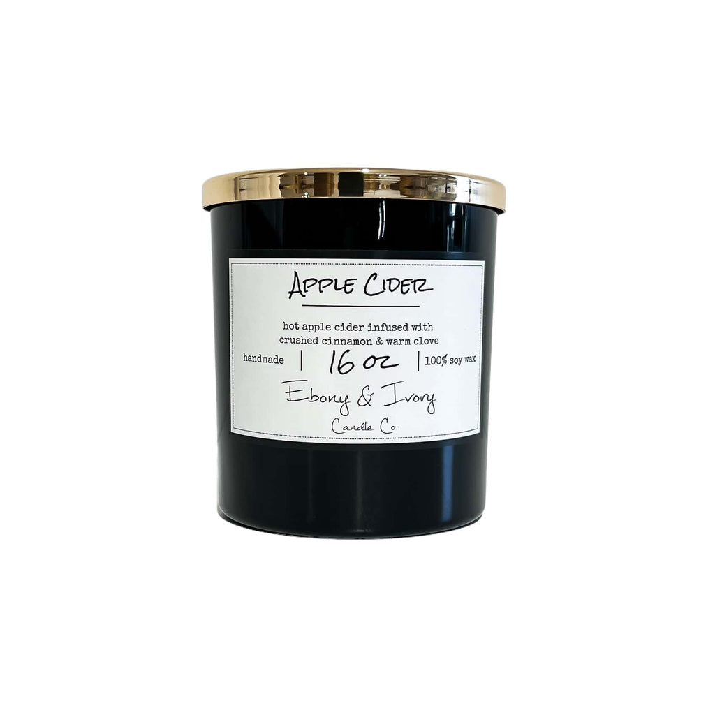 Black sixteen ounce, apple, cinnamon, and clove scented soy wax candle with a gold lid and a white label that reads Apple Cider