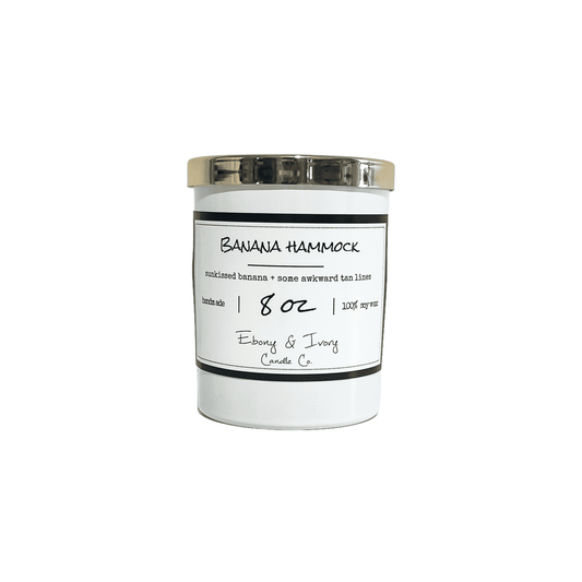 white, eight ounce, Banana and vanilla scented soy wax candle with a white label that reads Banana Hammock