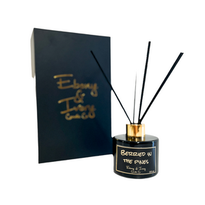 Black one hundred milliliters, blue spruce and huckleberry scented reed diffuser with a gold lid and a black label that reads Berried in the Pines