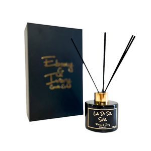 Black, one hundred milliliter, lemongrass, lilac, and patchouli scented reed diffuser with a gold lid and a black label that reads La Di Da Spa