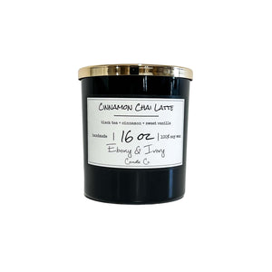 Black, sixteen ounces, black tea, cinnamon, and vanilla scented soy wax candle with a gold lid and a white label that reads Cinnamon Chai Latte