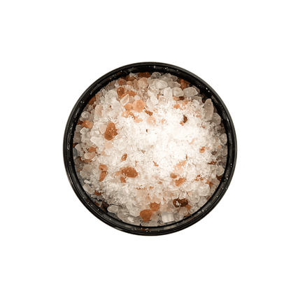 A top down shot of a Black container with a white label that reads "elixir" and is filled with pink Himalayan salt, dead sea salt, epsom salt, and peppermint essential oils. Made by Ebony & Ivory Candle Co in Lethbridge, Alberta, Canada