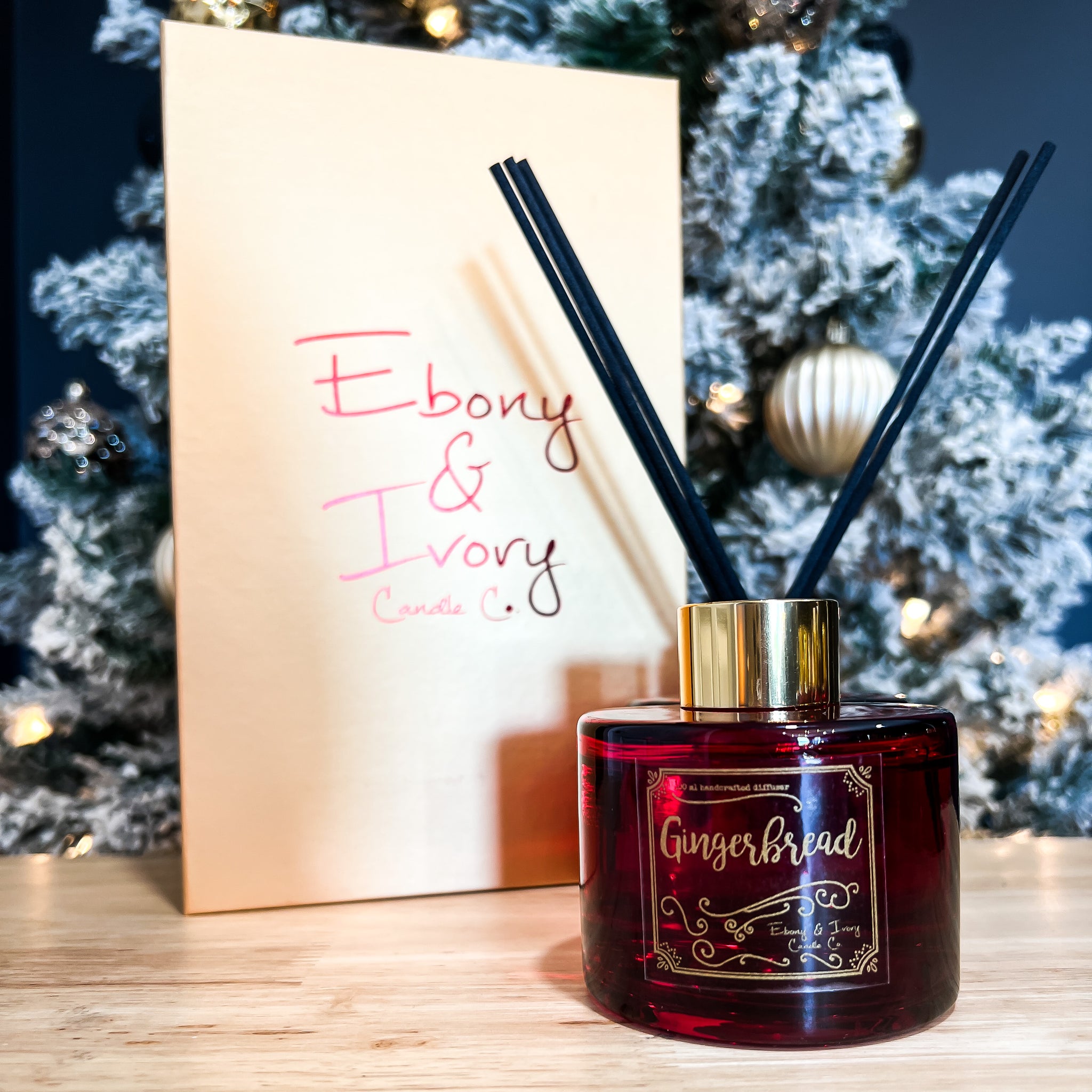 Red, one hundred milliliter, gingerbread scented reed diffuser with a gold lid and label