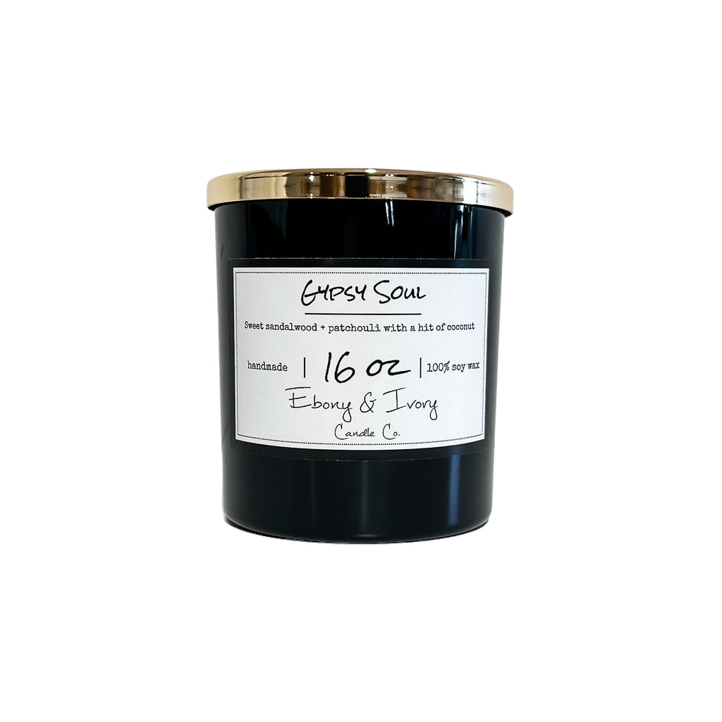 Black, sixteen ounce, Sandalwood, Patchouli, and coconut scented soy wax candle with a gold lid and a white label that reads Gypsy Soul