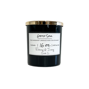 Black, sixteen ounce, Sandalwood, Patchouli, and coconut scented soy wax candle with a gold lid and a white label that reads Gypsy Soul