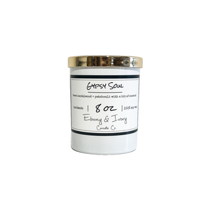 White, eight ounce, Sandalwood, Patchouli, and coconut scented soy wax candle with a gold lid and a white label that reads Gypsy Soul