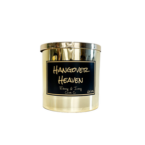 Gold, sixty four ounce, white tea, ginger, peach, and chardonnay scented soy wax candle with a gold lid and a black label that reads Hangover Heaven