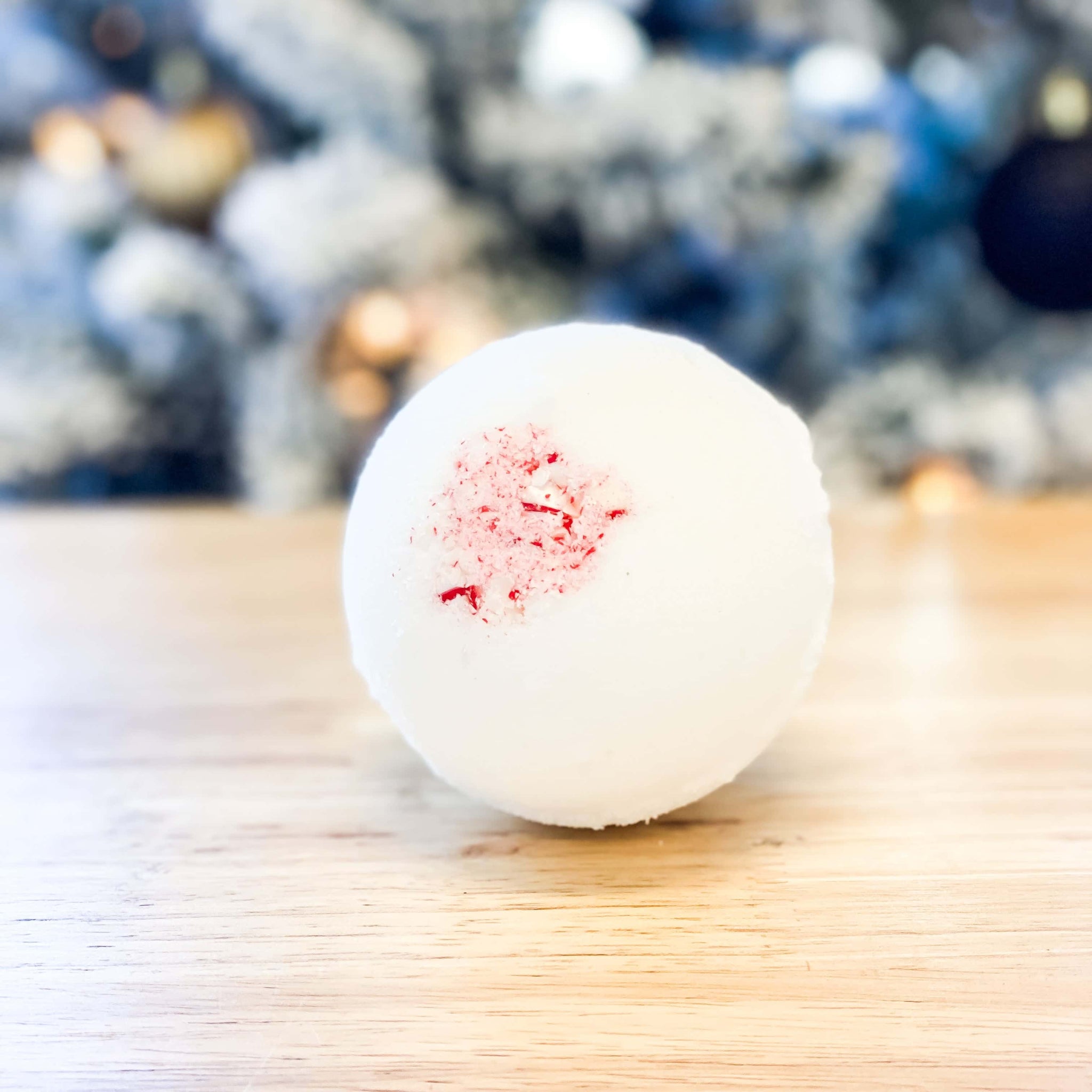 white holiday scented bath bomb with candy canes on top