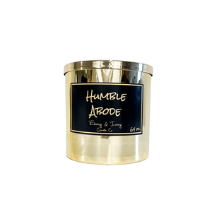 Gold, sixty four ounce, snickerdoodle, cupcake, vanilla, and brown sugar scented soy wax candle with a gold lid and a black label that reads Humble Abode