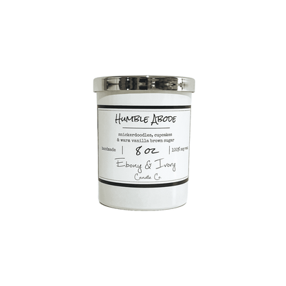 A white 8oz jar soy candle with a gold lid and a white label named Humble Abode, on a white background, made by Ebony & Ivory Candle Co in Lethbridge, Alberta, Canada
