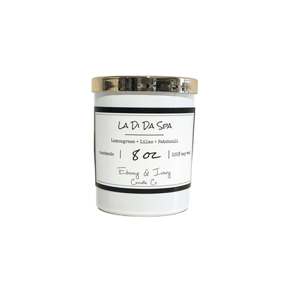 A white jar 8oz soy candle with a gold lid and a white label named La Di Da Spa, on a white background, made by Ebony & Ivory Candle Co in Lethbridge, Alberta, Canada
