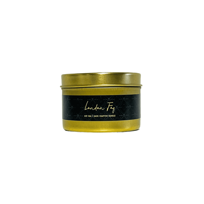 A gold 4oz tin soy candle with a black label named London Fog, on a white background, made by Ebony & Ivory Candle Co in Lethbridge, Alberta, Canada