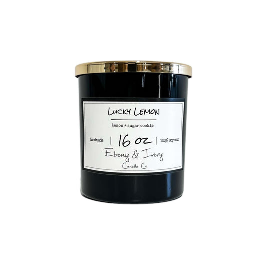 A black jar 16oz soy candle with a gold lid and a white label named Lucky Lemon, on a white background, made by Ebony & Ivory Candle Co in Lethbridge, Alberta, Canada