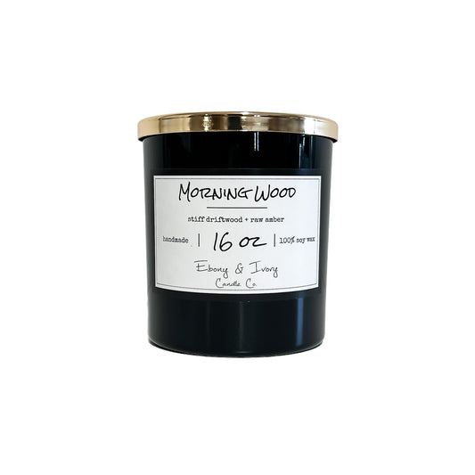 Black, sixteen ounce, driftwood and amber scented soy wax candle with a gold lid and a white label that reads Morning Wood