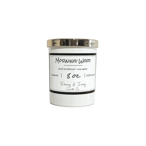 White, eight ounce, driftwood and amber scented soy wax candle with a gold lid and a white label that reads Morning Wood
