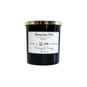 Black sixteen ounce, fraser fir tree scented soy wax candle with a gold lid and a white label that reads Mountain Fir