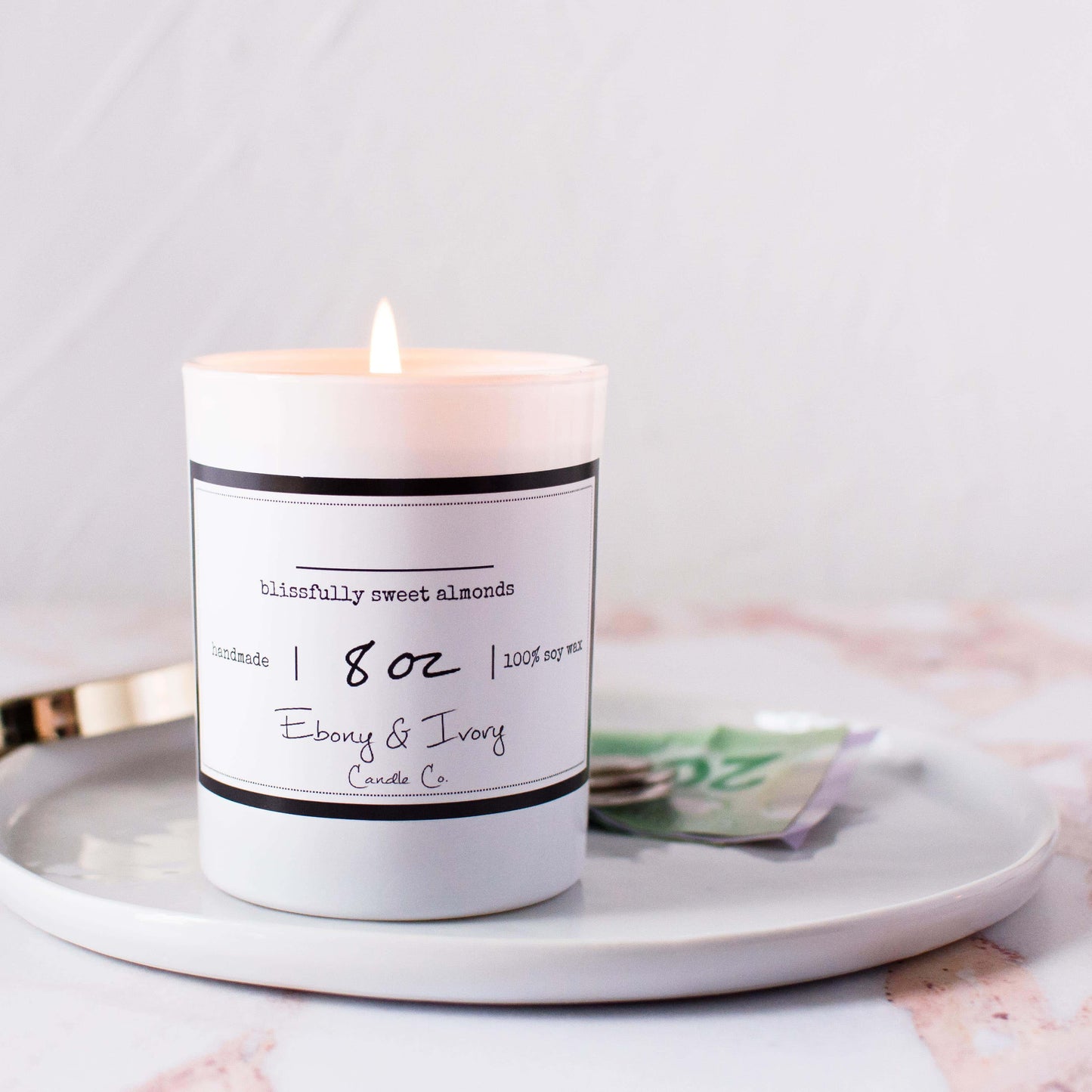 No name soy candle in an 8oz white jar sitting on a clean white ray with money in the background, made by Ebony & Ivory Candle Co in Lethbridge, Alberta, Canada