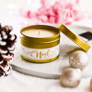 Gold, four ounce, cedar, fir, cinnamon, clove, orange, and lemon scented soy wax candle with a white label and a gold lid