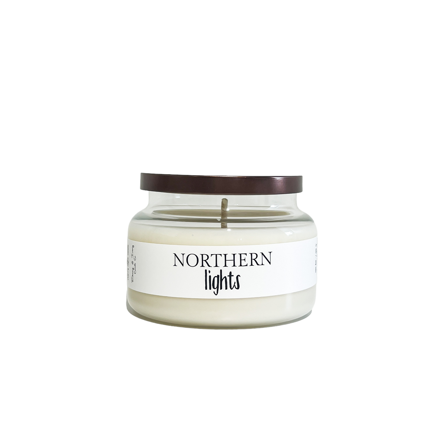 Clear glass, eight ounce, pine, cedar, eucalyptus, and lavender scented soy wax candle with a bronze lid and a white label that reads Northern Lights
