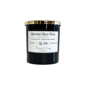 Black, sixteen ounce, mint and rosemary scented soy wax candle with a gold lid and a white label that reads Resting Mint Face