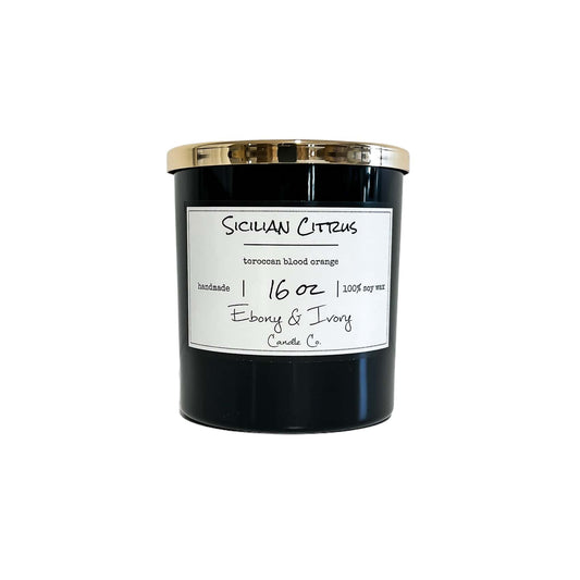 A black jar 16oz soy candle with a gold lid and a white label named Sicilian Citrus, on a white background, made by Ebony & Ivory Candle Co in Lethbridge, Alberta, Canada