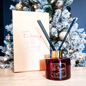 Red, one hundred milliliter, peppermint and vanilla scented reed diffuser with a gold lid and label