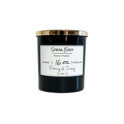 A black jar 16oz soy candle with a gold lid and a white label named Speak Easy, on a white background, made by Ebony & Ivory Candle Co in Lethbridge, Alberta, Canada