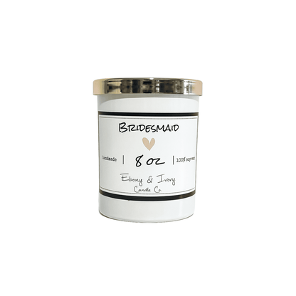 A white jar 8oz soy candle with a gold lid and a white label named Bridesmaid, on a white background, made by Ebony & Ivory Candle Co in Lethbridge, Alberta, Canada