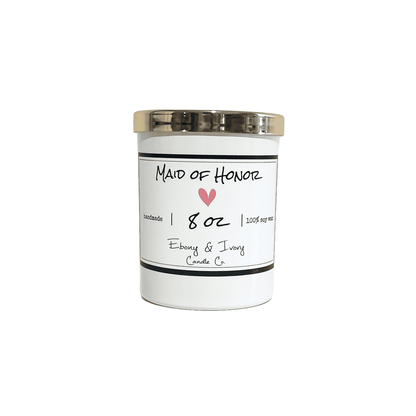White, eight ounce, scented soy wax candle with a gold lid and a white label that reads Maid of Honor with a pink heart below
