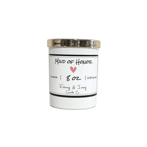 White, eight ounce, scented soy wax candle with a gold lid and a white label that reads Maid of Honor with a pink heart below