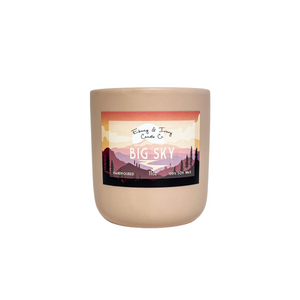 Blush pink, eleven ounce, scented soy wax candle labeled Big Sky